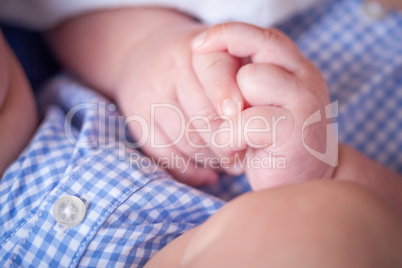 Close-up Of Infant Hands While Laying on Lap of Mother