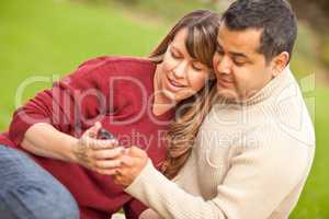 Attractive Mixed Race Couple Enjoying Their Camera Phone in the
