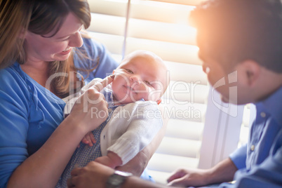 Happy Mixed Race Couple Enjoying Their Newborn Son In The Light