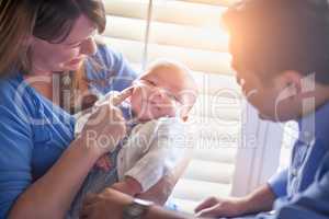 Happy Mixed Race Couple Enjoying Their Newborn Son In The Light