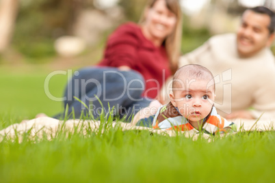 Happy Crawling Baby Boy and Mixed Race Parents Playing in the Pa