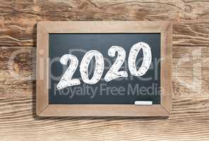 2020 Written on Slate Chalk Board Against Aged Wood Background