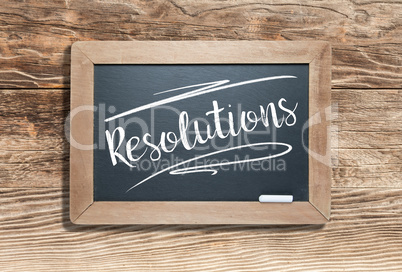Resolutions Written on Slate Chalk Board Against Aged Wood Backg