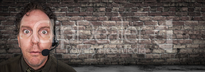 Stunned Businessman Wearing Phone Headset In Office With Brick W