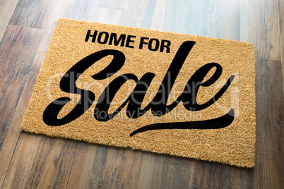 Home For Sale Welcome Mat On A Wood Floor Background