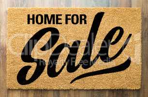 Home For Sale Welcome Mat On A Wood Floor Background
