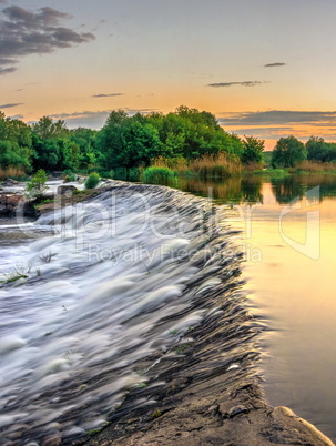 Beautiful view of the dam on the river at sunset