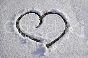 Heart drawn on white clear thin snow