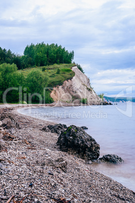 stone on the riverbank and cliff with woodland on background