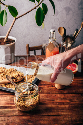 Man pouring milk on cereals