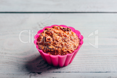 Oatmeal muffin in pink bakeware.