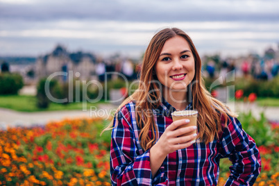 Beautiful young woman holding coffee cup and smiling