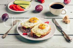 Bruschettas with vegetables and fried egg, cup of coffee and som