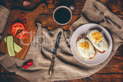 Breakfast toasts with vegetables and fried eggs with cup of coff