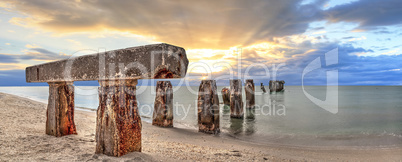 Sunset over old abandoned stone fishing pier called Bocahenge