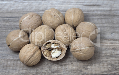 Delicious whole walnuts on wooden background.