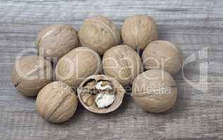 Delicious whole walnuts on wooden background.
