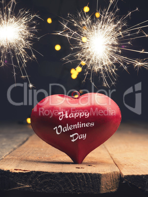 Red heart shape with sparkler on a wooden table