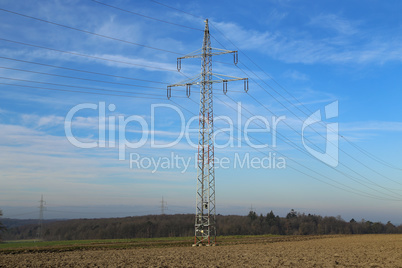 Landscape with electric pylons against the blue sky