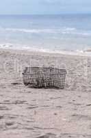Crab and lobster trap washed up on the white sand beach of Tiger