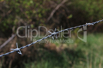 barbed wire with burred image of field