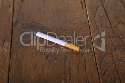 Filter cigarette lies on a wooden table