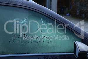 Drawing on frozen car windows on a frosty morning