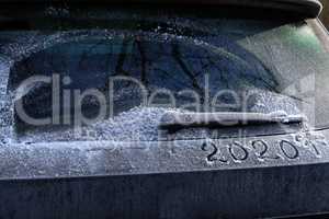 Drawing on frozen car windows on a frosty morning