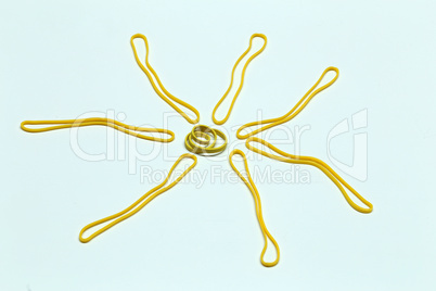 Yellow sun from colored rubber bands on a white background