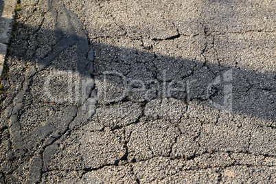 Cracks of asphalt close up. Street texture.