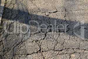 Cracks of asphalt close up. Street texture.