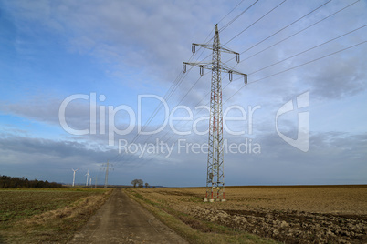 Landscape with high-voltage masts against the blue sky