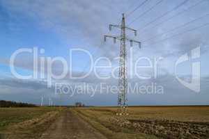 Landscape with high-voltage masts against the blue sky