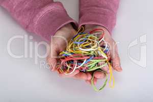 Many colored elastic bands in the hands