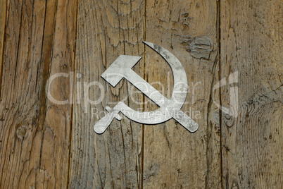 Sickle and hammer lying on wooden background
