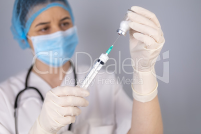 Doctor hands filling the syringe with vaccine