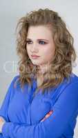 Girl is blonde with curly hair in a bright blue shirt.