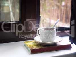 A Cup of tea and a book on the windowsill