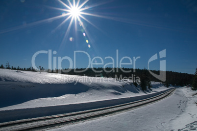 Railroad track near the mountain called Brocken with lens flare