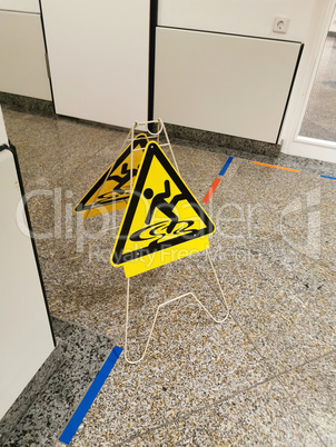 Yellow wet floor warning sign on the floor