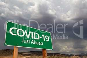 COVID-19 Coronavirus Green Road Sign Against Ominous Stormy Clou