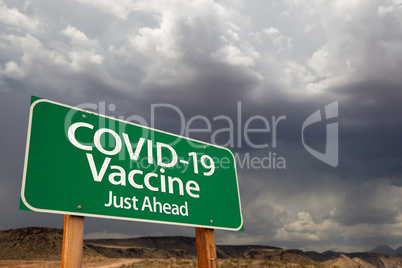 COVID-19 Coronavirus Vaccine Green Road Sign Against Ominous Sto
