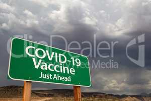 COVID-19 Coronavirus Vaccine Green Road Sign Against Ominous Sto