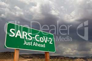 SARS-CoV-2 Coronavirus Green Road Sign Against Ominous Stormy Cl