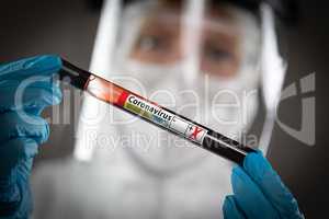 Female Lab Worker Holds Test Tube of Blood Labeled Coronavirus C