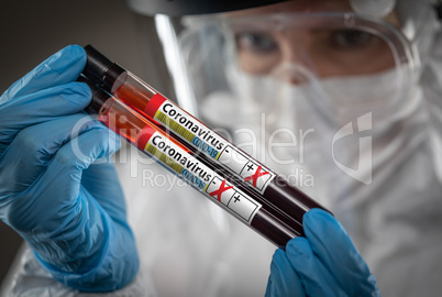 Female Lab Worker Holds Test Tubes of Blood Labeled Coronavirus