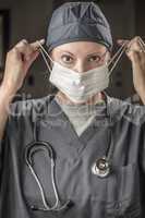 Female Doctor or Nurse with Stethoscope Putting On Protective Fa
