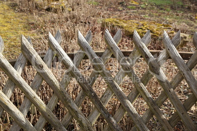 Wooden wattle fence in a garden near a rural house