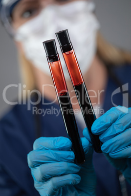 Female Lab Worker Wearing Medical Face Mask Holds Test Tubes of