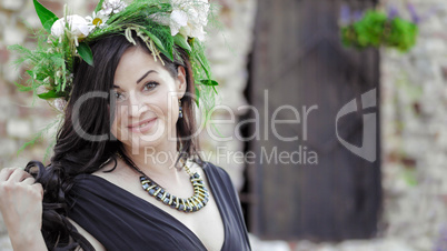 Woman in the spring. A wreath of meadow grass and flowers is worn on the brunette's head. White peonies adorn the head of a young lady. A girl in a long black sleeveless dress.